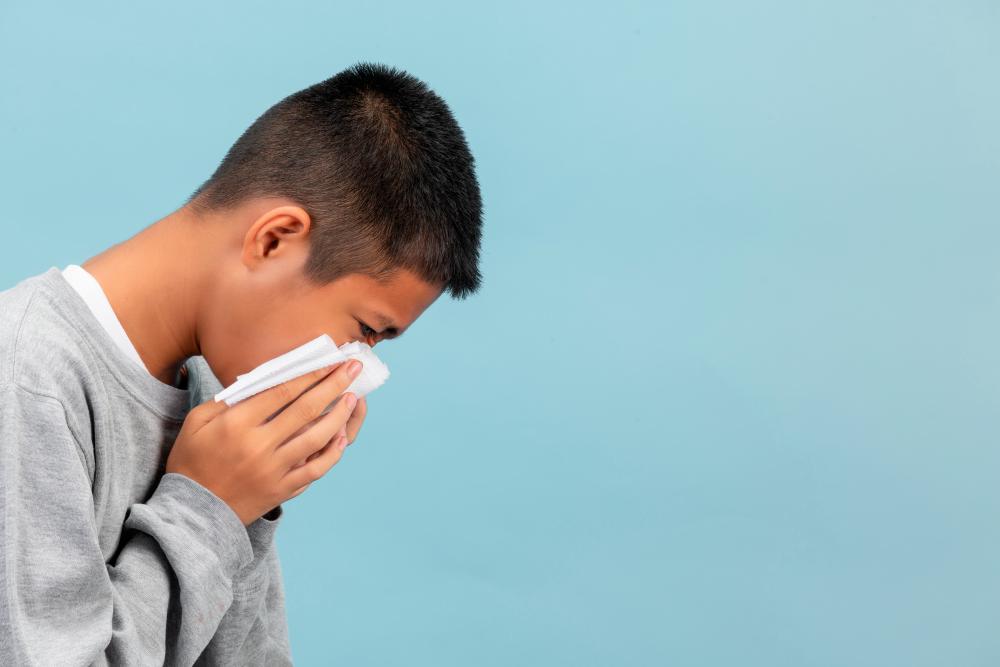 boy is sneezing into tissue feeling sick blue wall 4054606 20240418154237